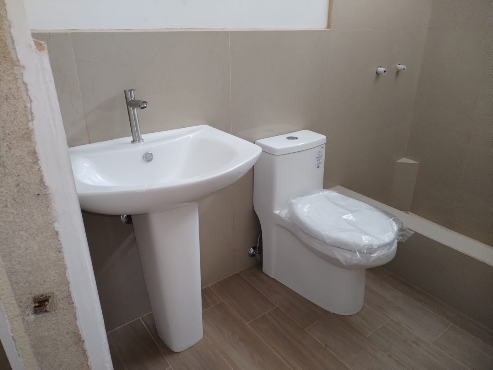 Instalación sanitaria terminada con lavamanos e inodoro en proyecto de remodelación